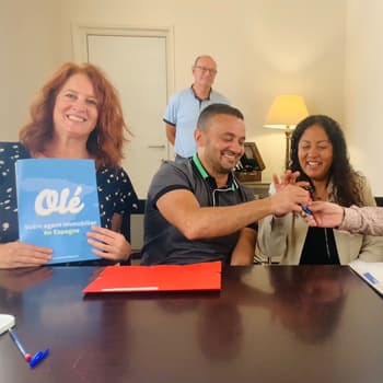 A female real estate hunter with a couple at the notary’s office, receiving the keys to their new home