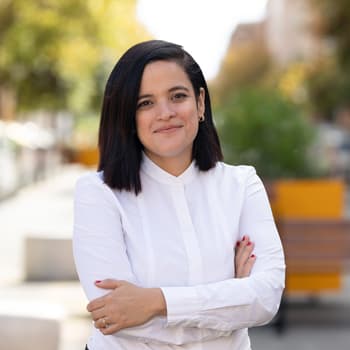 A stylish woman in a white shirt walking down the street