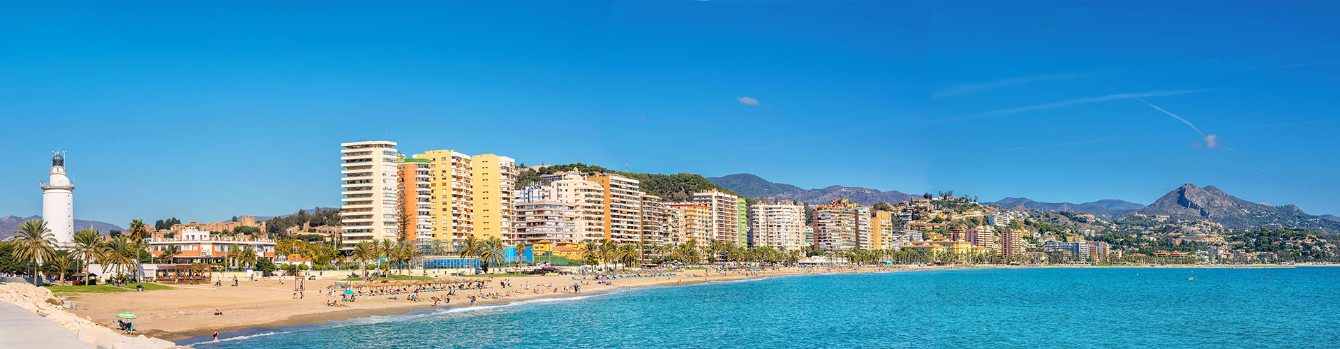 Panoramic view of a coastal city in Spain with beaches, high-rise buildings and mountains, illustrating the appeal of buying property in Spain in 2025