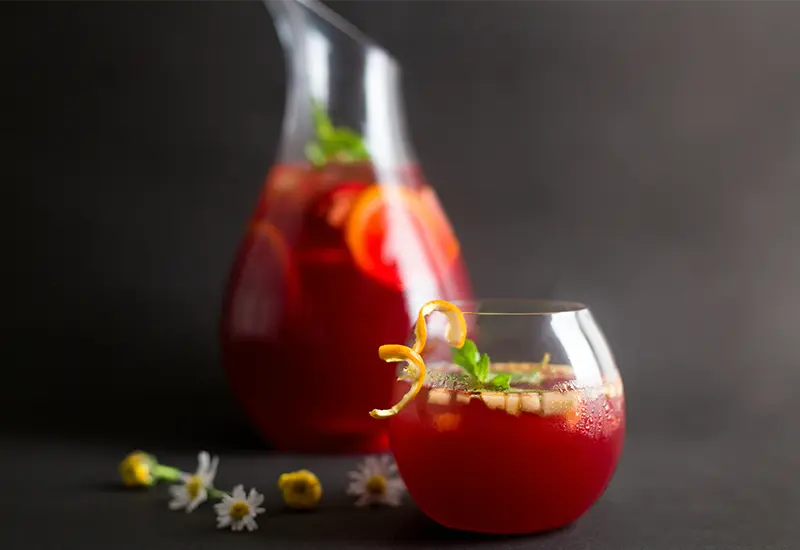 Glass and pitcher of sangria with fruits, symbolizing Spain’s most famous traditional drink