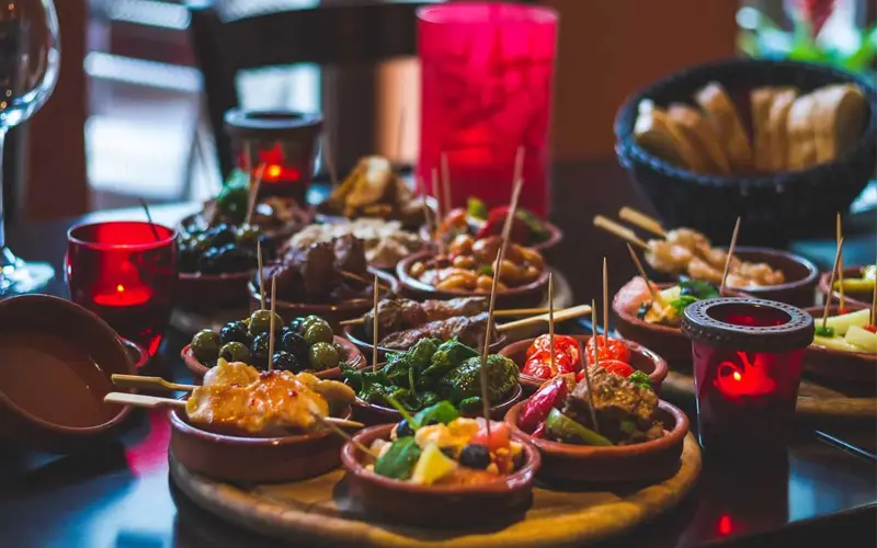 Assortment of traditional Spanish tapas with olives, vegetables and meats served in small portions