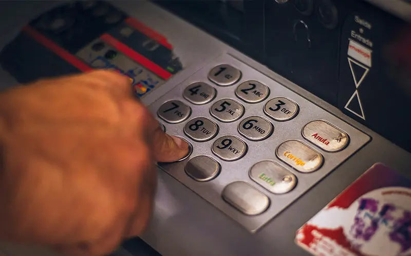 Hand entering a code on an ATM in Spain, representing banking services and cash withdrawals