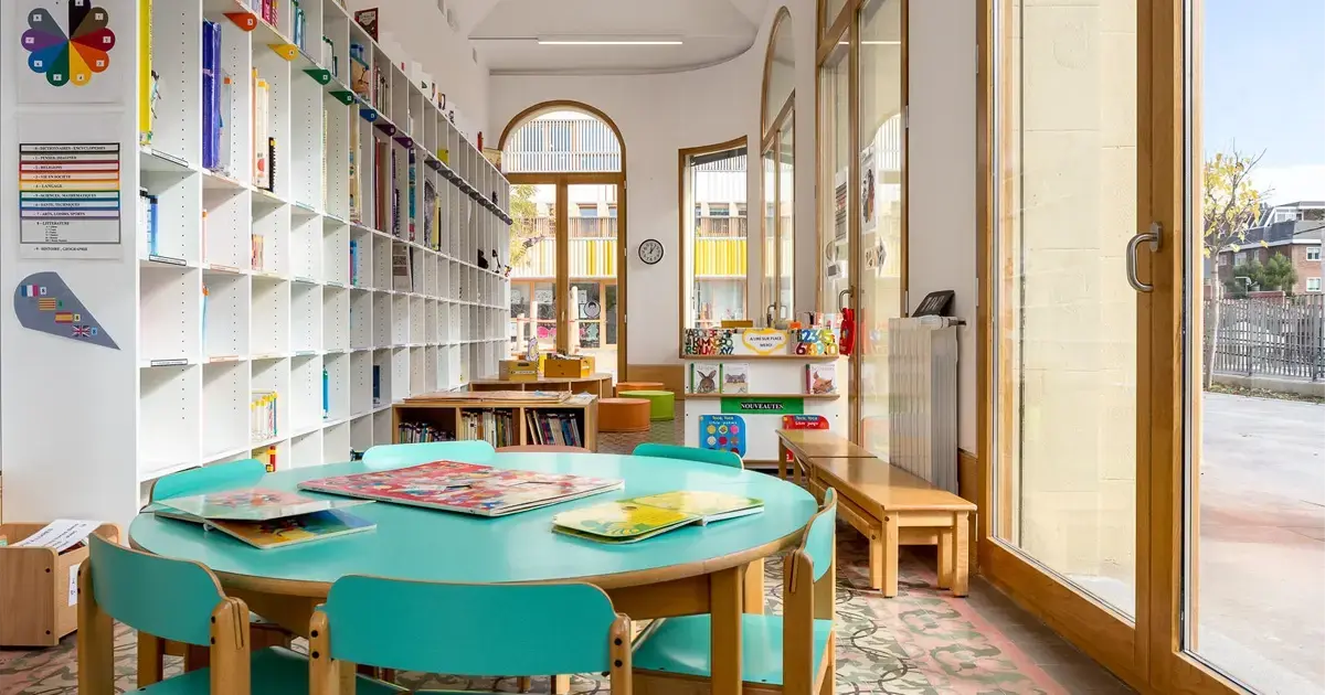 Colorful kindergarten classroom in Spain with books and educational games, illustrating early education.