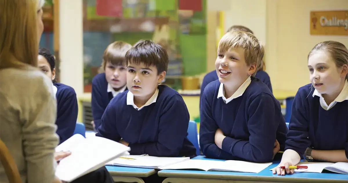Children in a Spanish primary school classroom listening to their teacher, part of the Spanish education system.