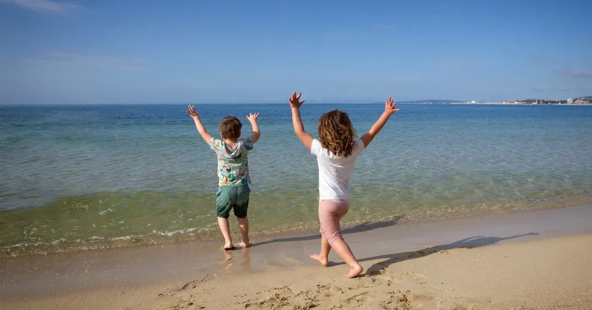 Children enjoying school holidays on the beach in Spain, illustrating the Spanish academic calendar.