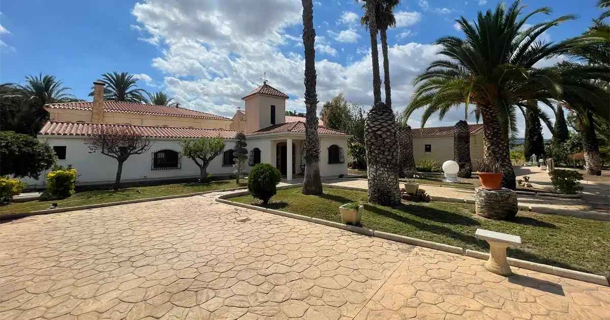 Traditional Spanish villa surrounded by palm trees, illustrating Spanish real estate opportunities for foreign buyers in 2025