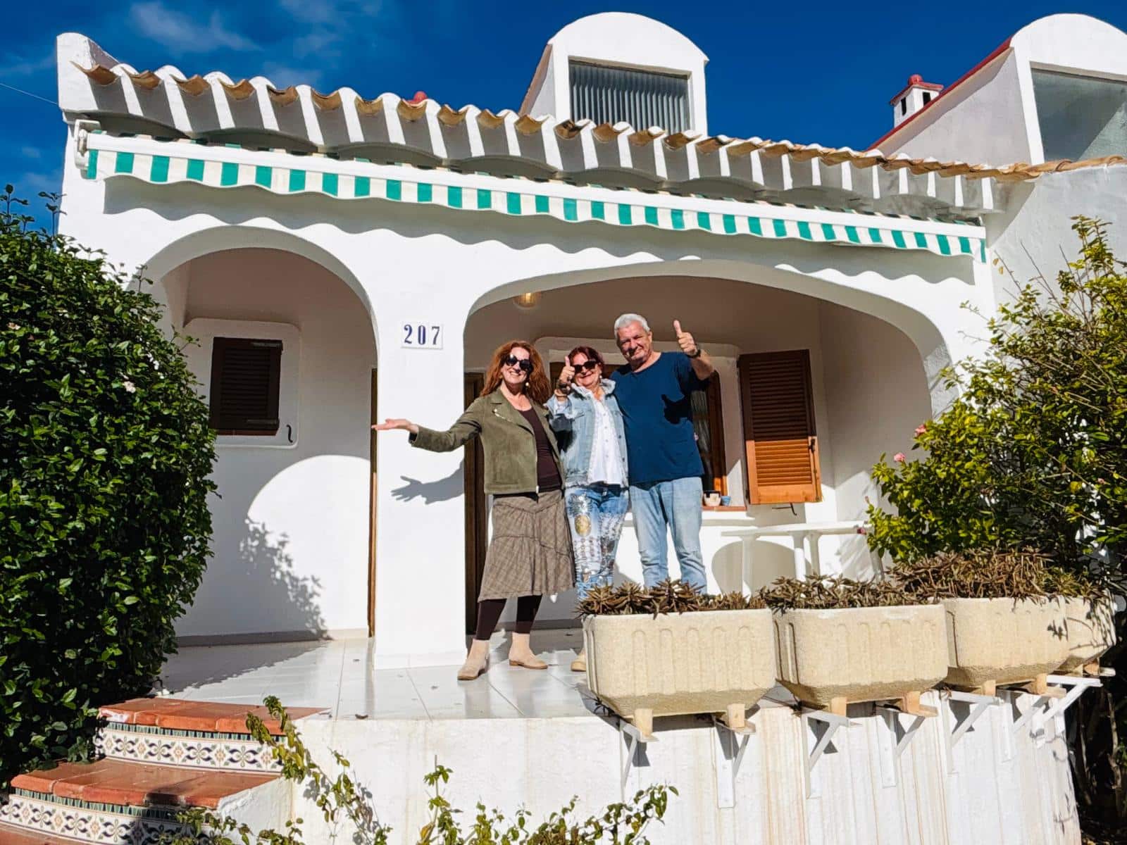 Property hunter with her clients in front of a house in Spain